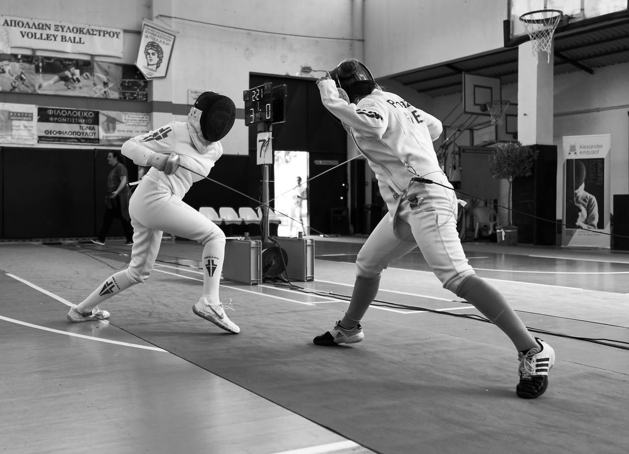 Two epee fencers in a club tournament bout